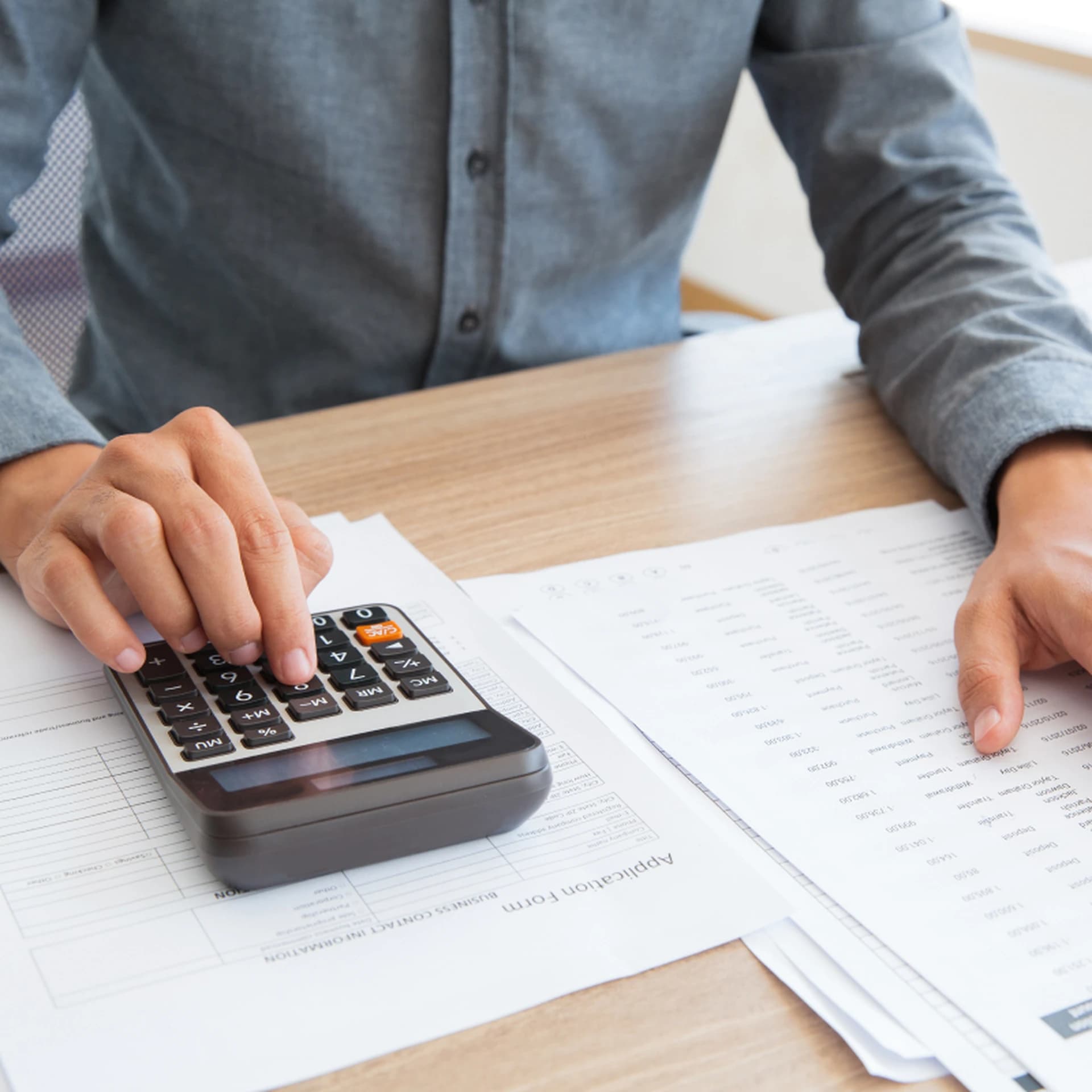 Documentos fiscales sobre una mesa junto a una calculadora